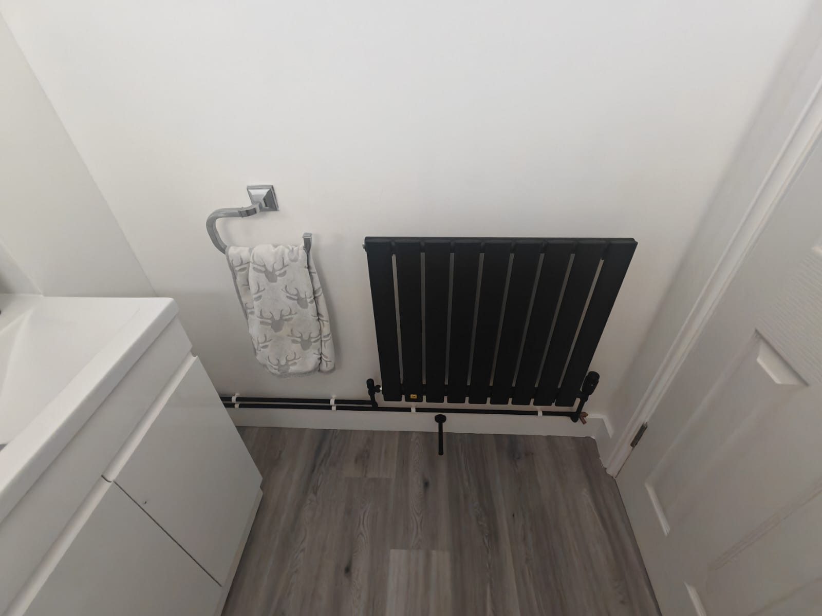 Black designer radiator installed in a refurbished bathroom